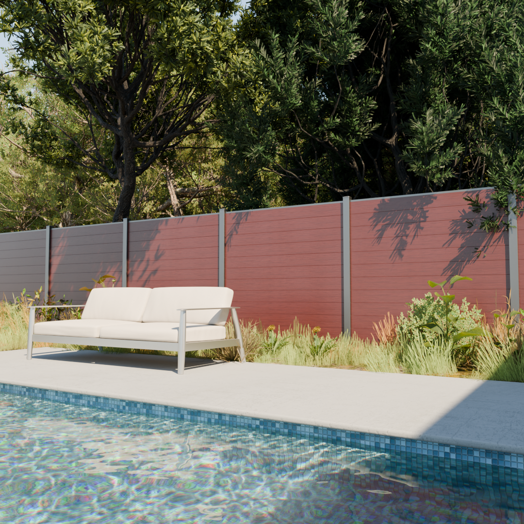 composite-135-inspiration-redwood-lounge-fence Redwood-look composite privacy fence with gray posts beside a swimming pool, outdoor sofa, and landscaped greenery.